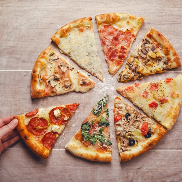 A hand reaches for a slice of pepperoni pizza, surrounded by seven other diverse pizza slices.